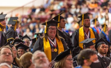 Students stand during commencement and are recognized for their academic accomplishments. 