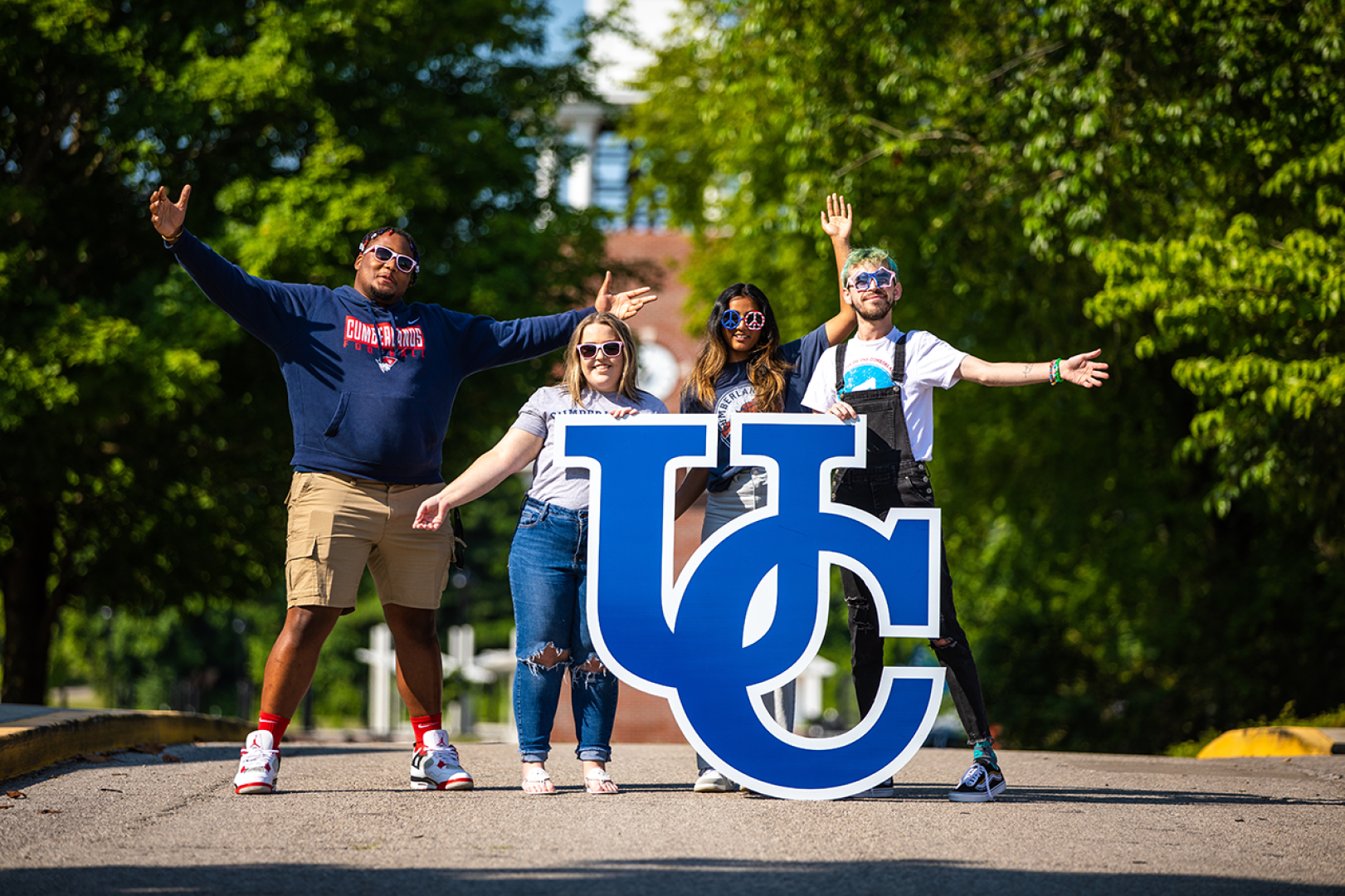 University of the Cumberlands student pose on campus with a UC sign. 