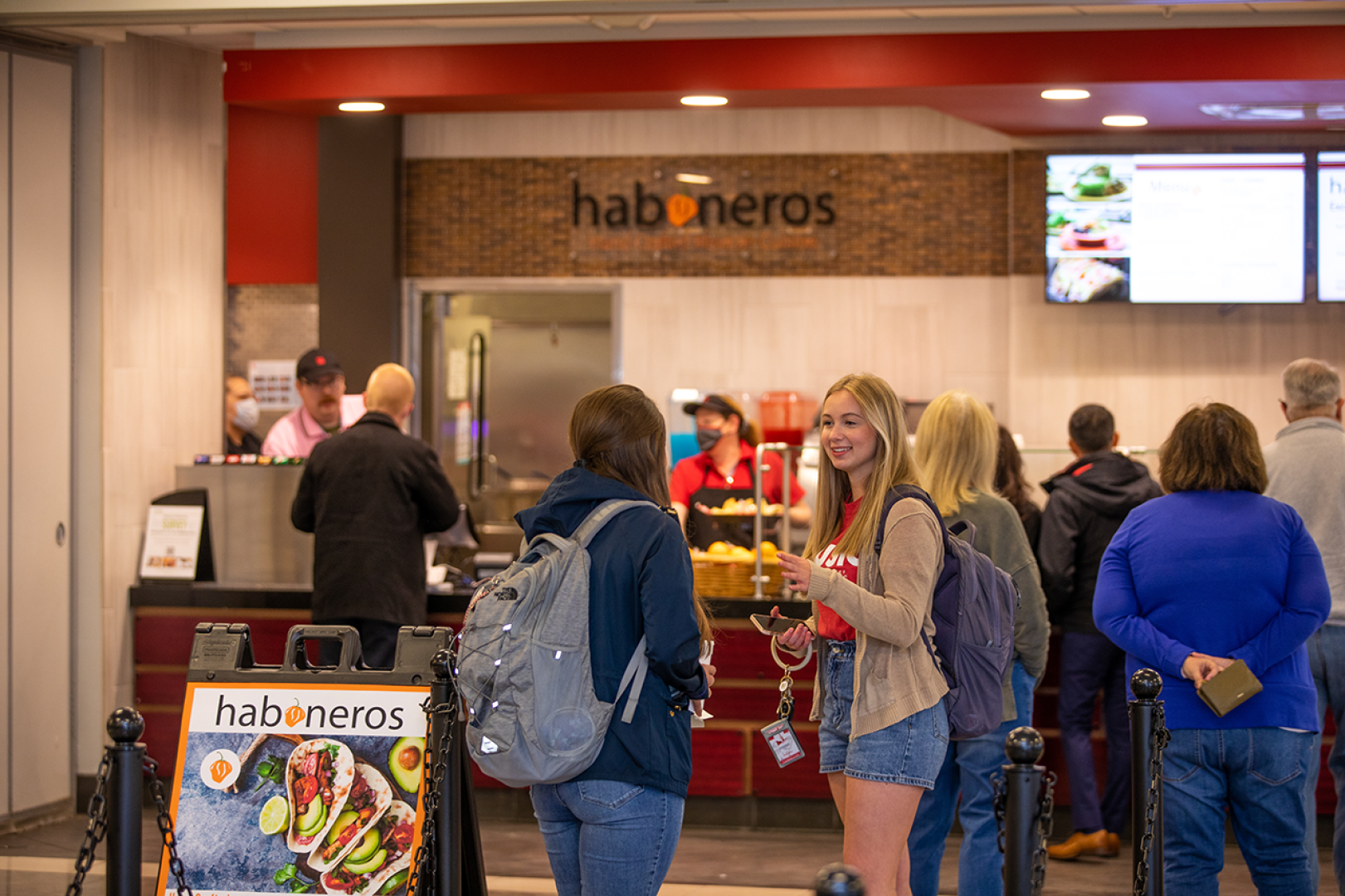 Students are waiting in line for lunch in the campus grille. 