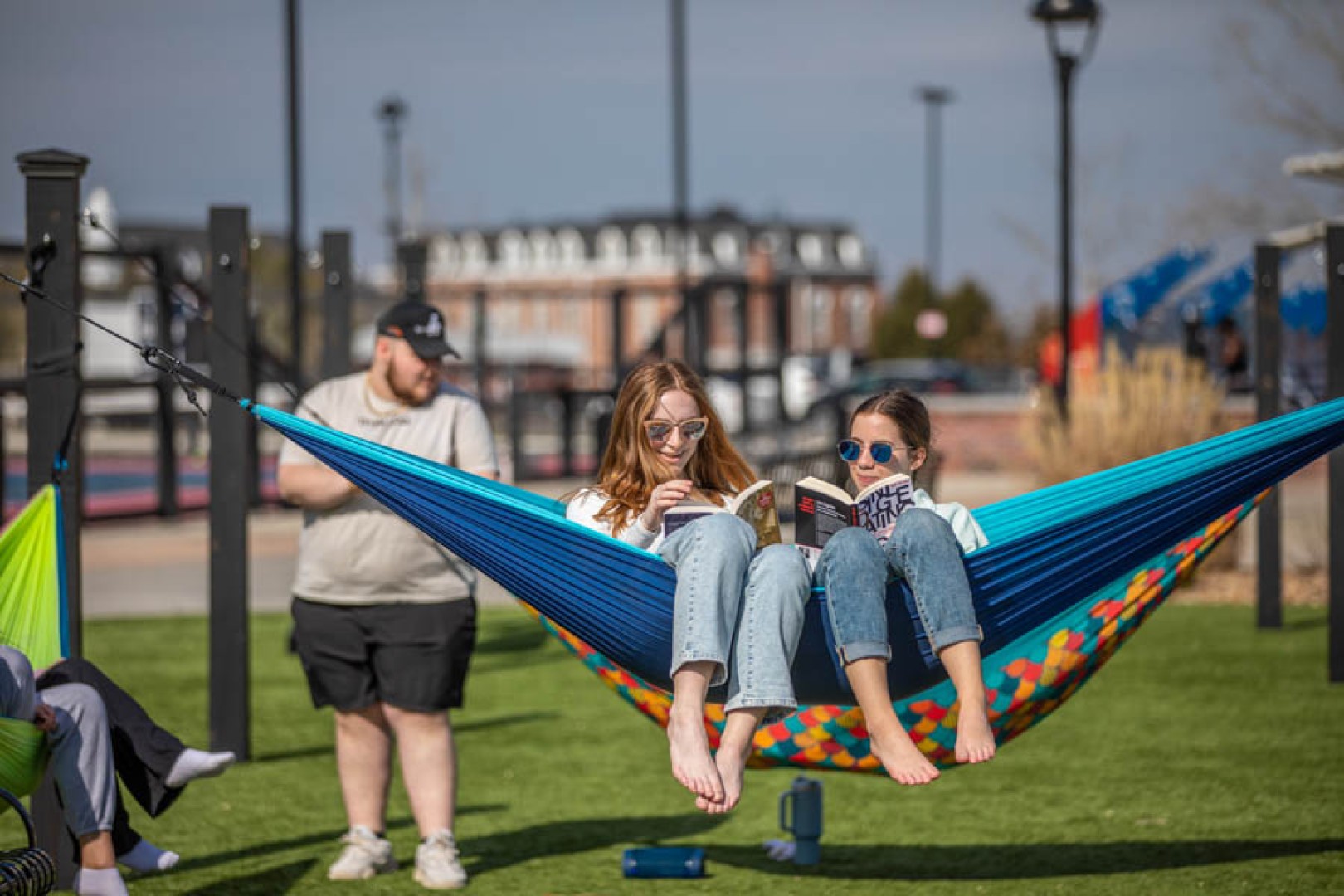 Friends reading while sitting in a hammock