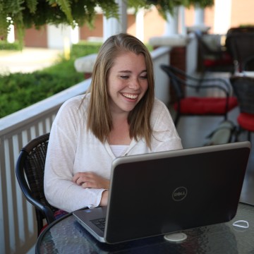 A student on a laptop outside