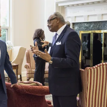 An older man speaking to a young adult