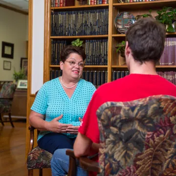 A woman speaking with a young man