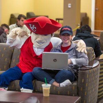 The university mascot posing with a student.