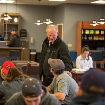 An older man speaking to a young adult