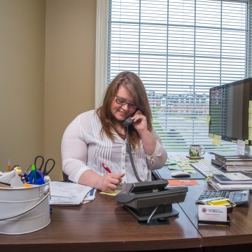 A student working at a desk answering a phone