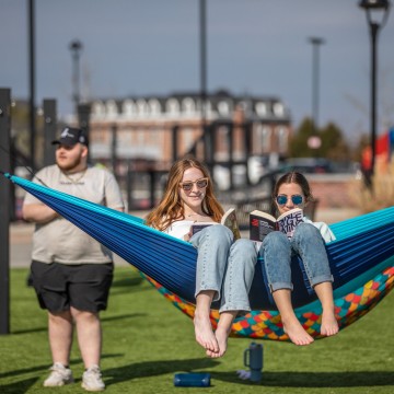Two students sitting on a hammock