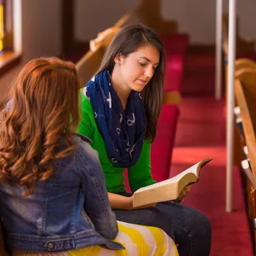 Two young adults sitting in a church