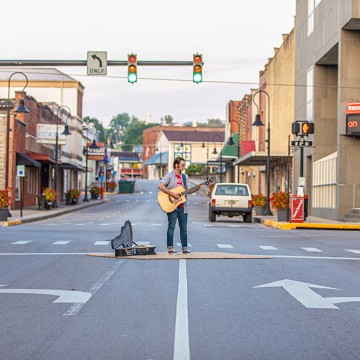 a man playing guitar in the street