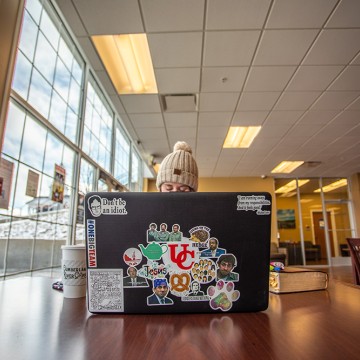 A girl studying on a snow day using a laptop.