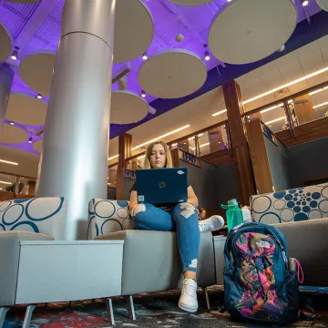A student using a laptop inside renovated library