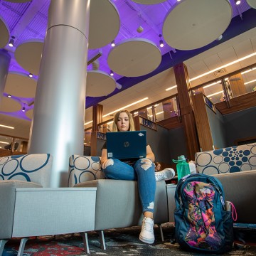 A student using a laptop inside renovated library