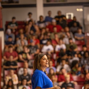 A speaker speaking to a room full of students