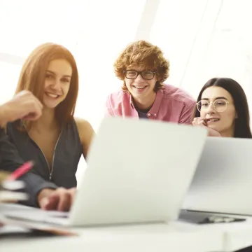 A group of people looking at a laptop