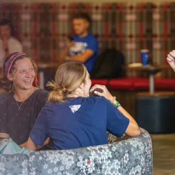 Students laugh while hanging out in the campus student center. 