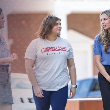 Students walk on campus while discussing their day. 