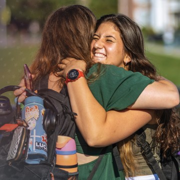 Students hug on their way to class. 