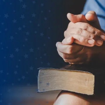 Clasped Hands Over Bible