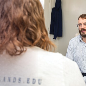 A student speaks to a counseling expert inside the counselor's office. 