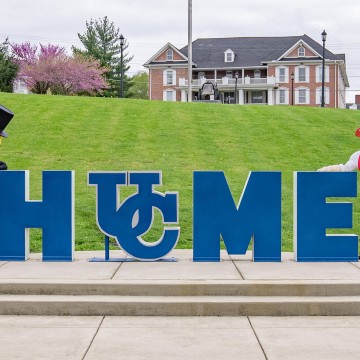 The Mr. Peanut mascot and Cumberlands mascot Patriot Pete stand by the home sign on campus. 