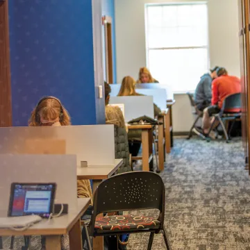 Students sit a kiosks in the library and study. 