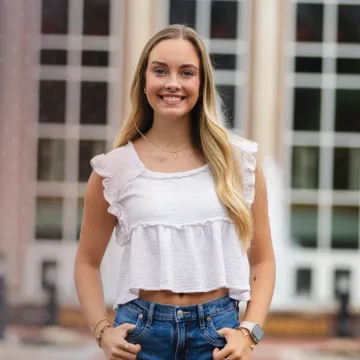 Commuter student Sydney Hurst posing in front of the library. 