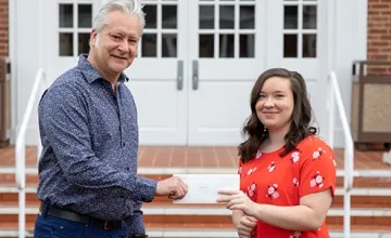 Two people holding an envelope 