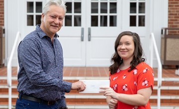 Two people holding an envelope 