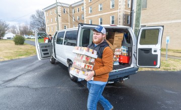 Students help deliver food to a local church food pantry during the annual food drive 
