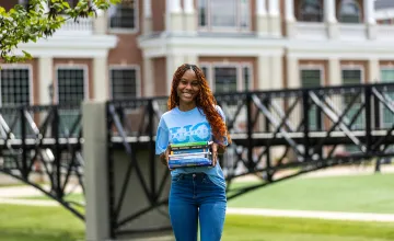 A student holds textbooks outside on Cumberlands campus. 
