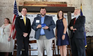 Campus Minister Jacob Ratliff is presented with a Governor's Service Award. 