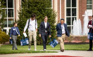 Students speak with a business professor following the annual forum. 