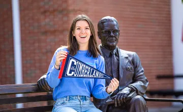 A Cumberlands alumna holds a pennant to display her school spirit. 