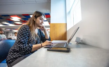 A graduate business student studies in the library. 