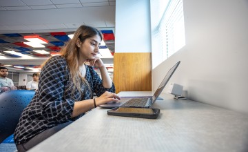 A graduate business student studies in the library. 