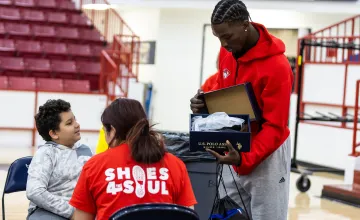Cumberlands students show a student from a local school a pair of new shoes during Shoes 4 the Soul. 