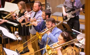 Band students practice a musical selection in the university recital hall. 