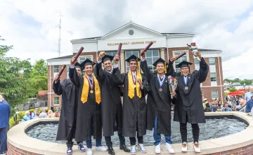 Students celebrate with their diploma following graduation.