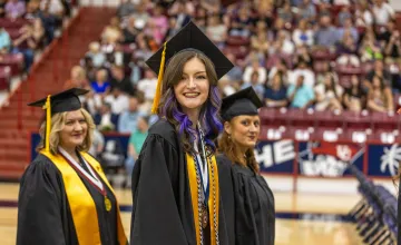 A student walks into her graduation ceremony. 