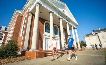 Students walk in front of the chapel on campus.