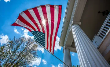 An American flag is displayed on a building on campus. 