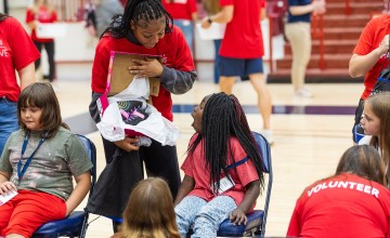A female college volunteer shows a local female elementary student a new pair of shoes during Cumberlands annual service event. 