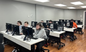 Students work on a computer exercise during a Day of Cyber event. 