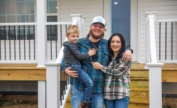 The Perry family poses for a photo in front of a new home constructed by Mountain Outreach. 