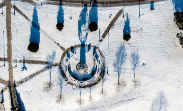 An aerial view of the globe statue on campus after a snow. 