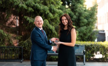 President Quentin Young presents an award to the 2026 presidential scholar.