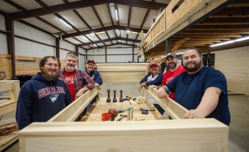 A group of Cumberlands staff members show off a bed they constructed during a service day event.