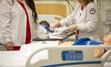 Two nursing students prepare to conduct a clinical examination. 