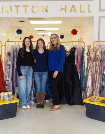 Cumberlands students Ella Edington, Abigail Wynn, and Caitlin Ball pose with prom dresses they have collected to give away to support local high school students. 