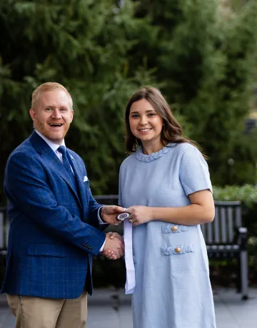 President Young presents a leadership award to student Isabella Watson.